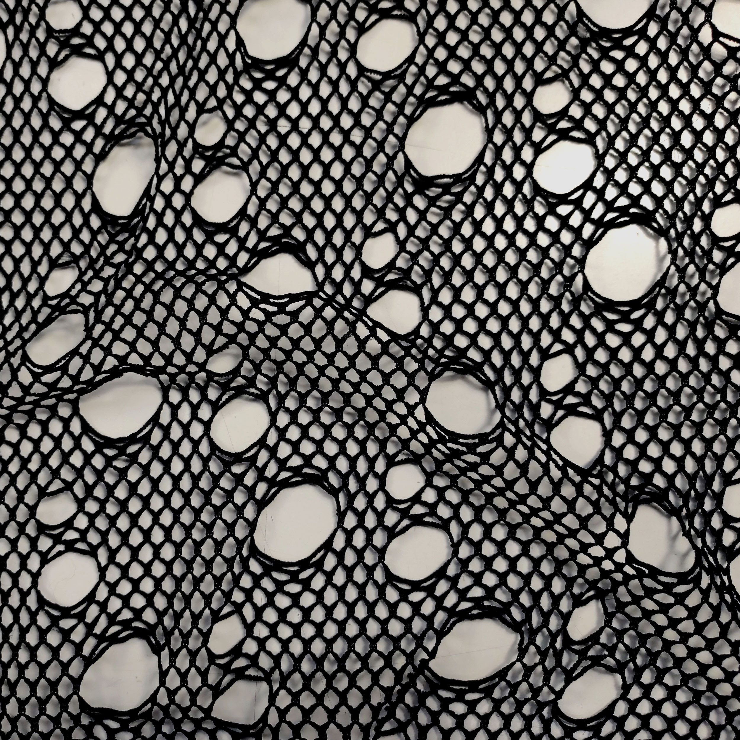 Schwarzer Mesh-Stoff mit Rissen