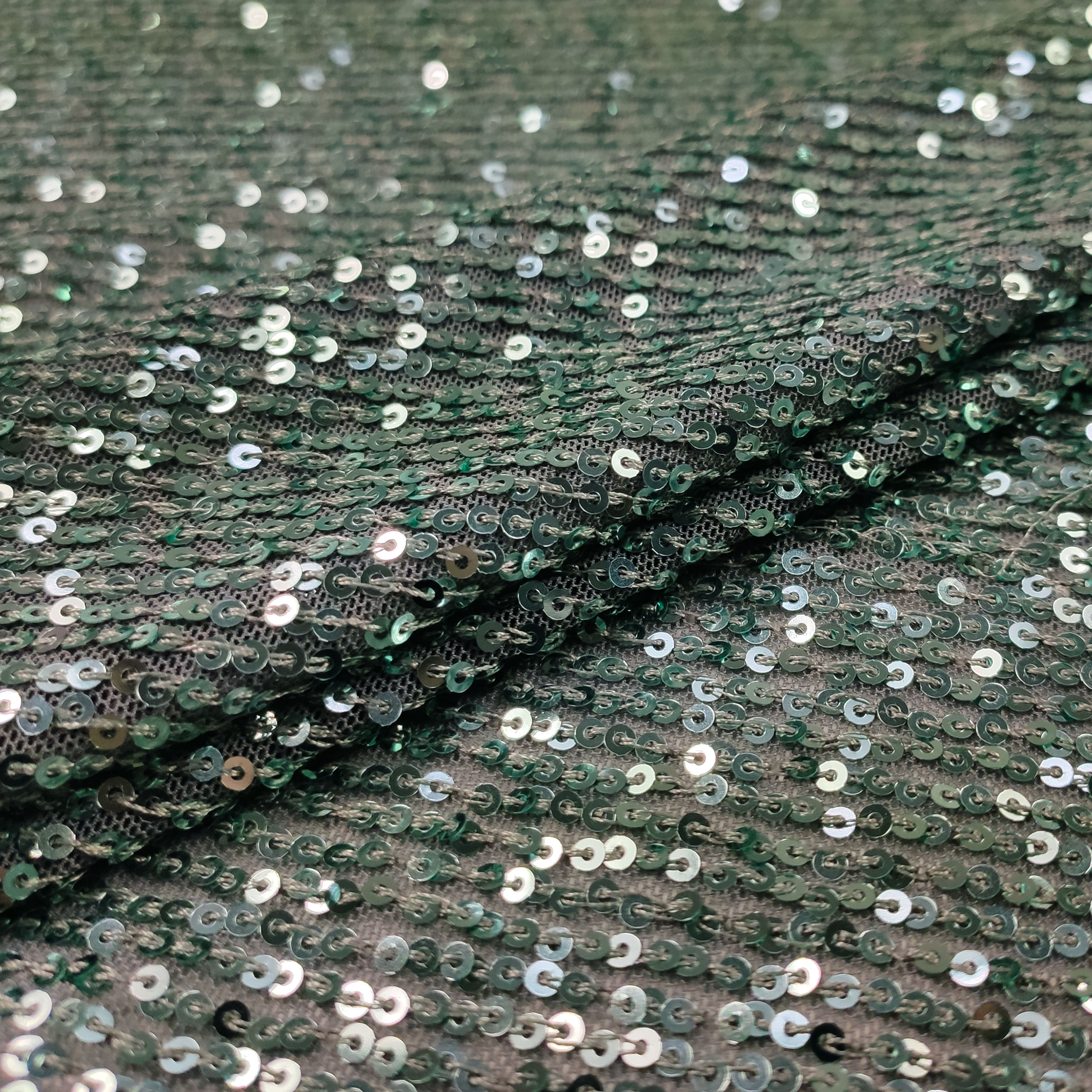 Paillettes vertes sur tissu de tulle gris