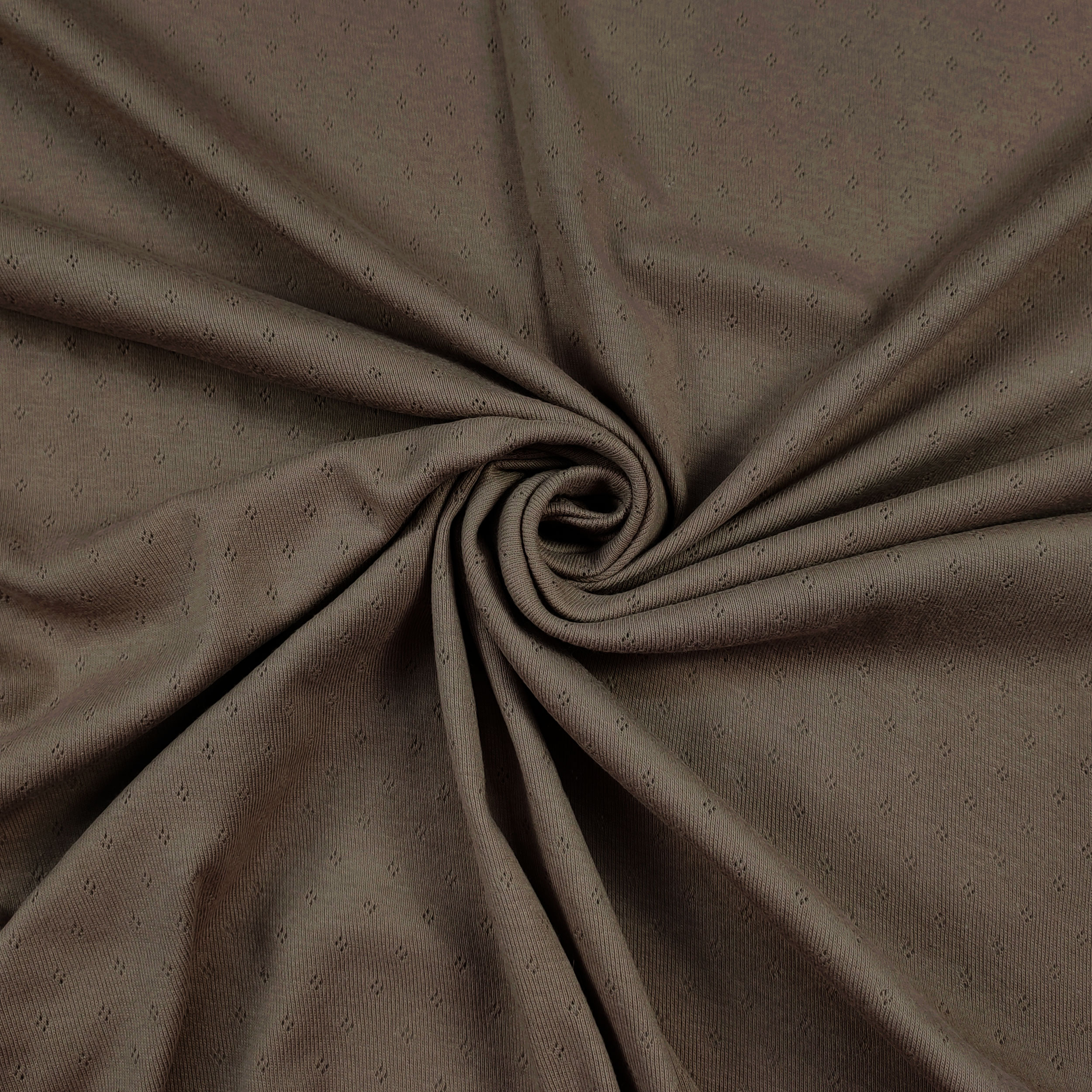 Flores perforadas en jersey de algodón sobre fondo beige oscuro
