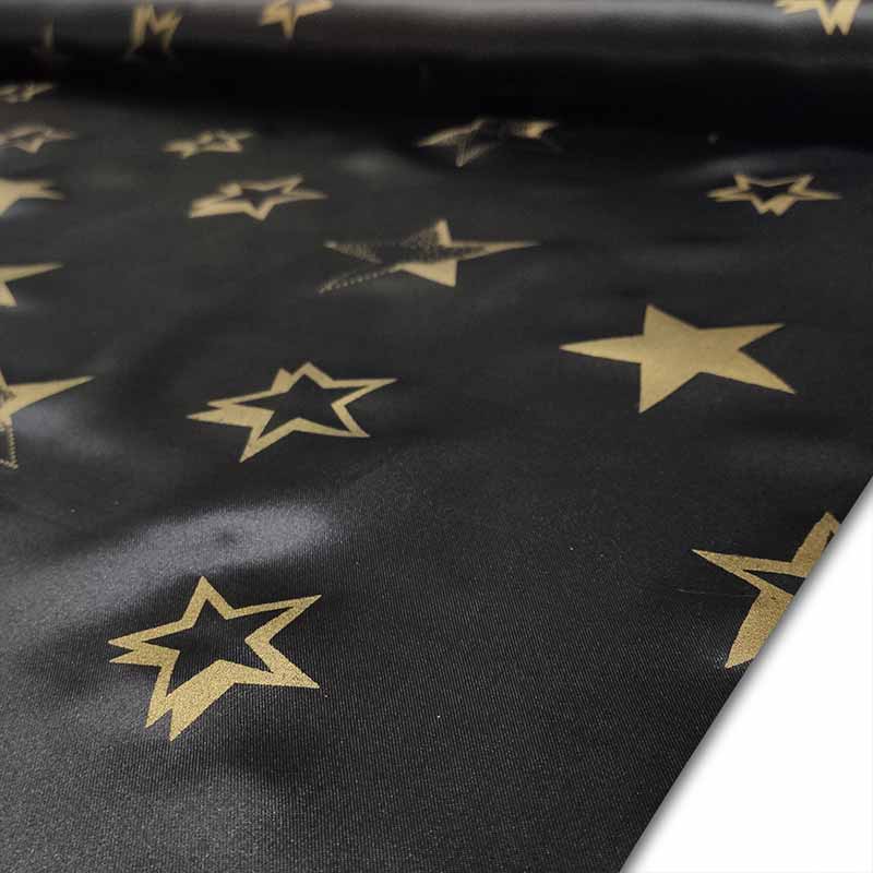 Schwarzer Karnevals-Satin-Stoff mit goldenen Sternen