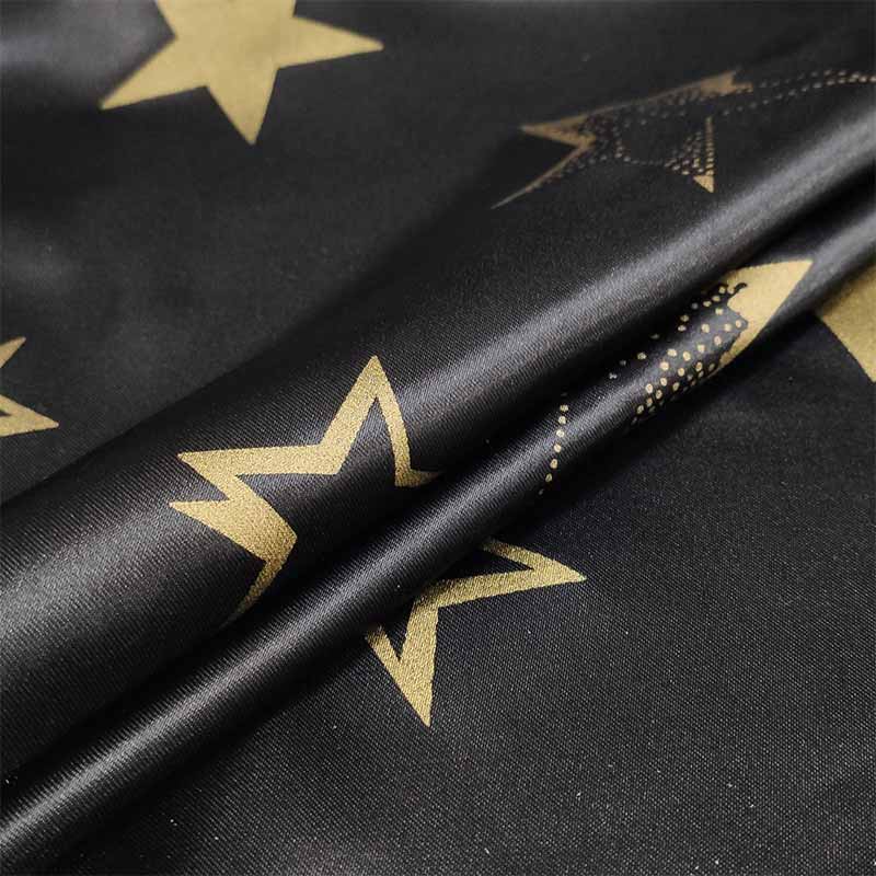 Schwarzer Karnevals-Satin-Stoff mit goldenen Sternen
